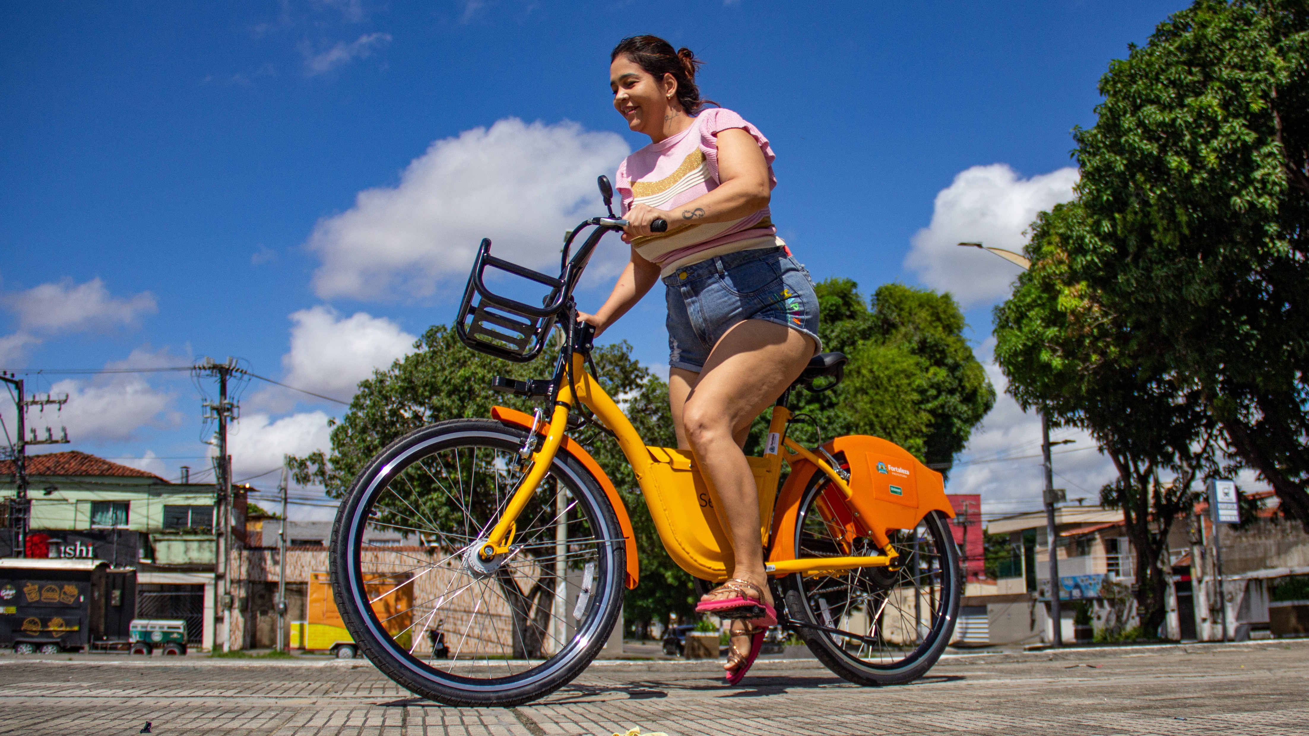 mulher andando numa bicicleta elétrica do Bicicletar numa praça